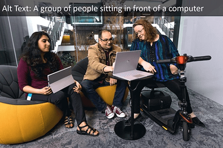 A group of people sitting in front of a computer.
